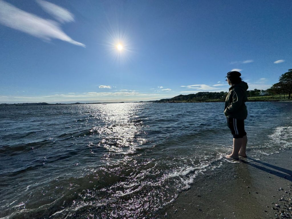 Standing on the shore.